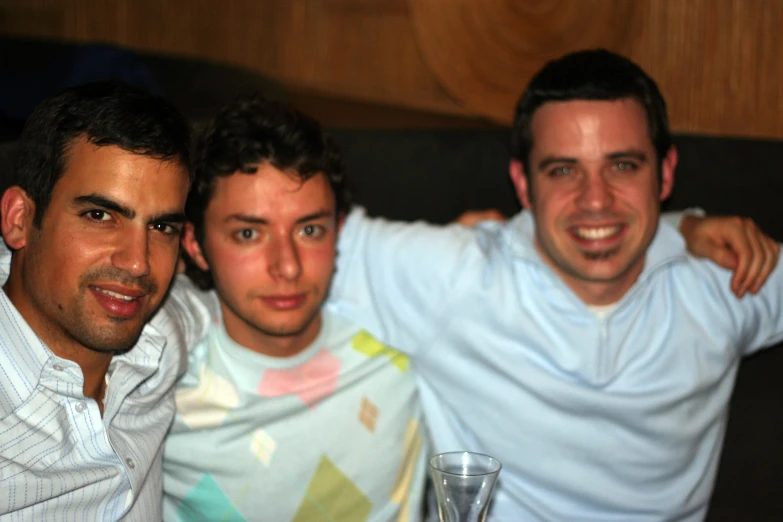 three men pose for a picture together at a party