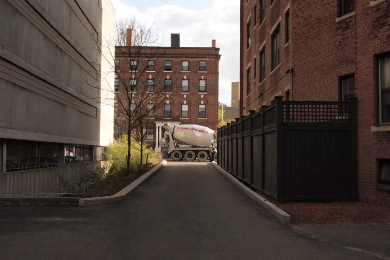 a white truck driving down a street near tall buildings