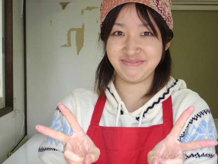 a woman with an orange and white hat on holding two hands