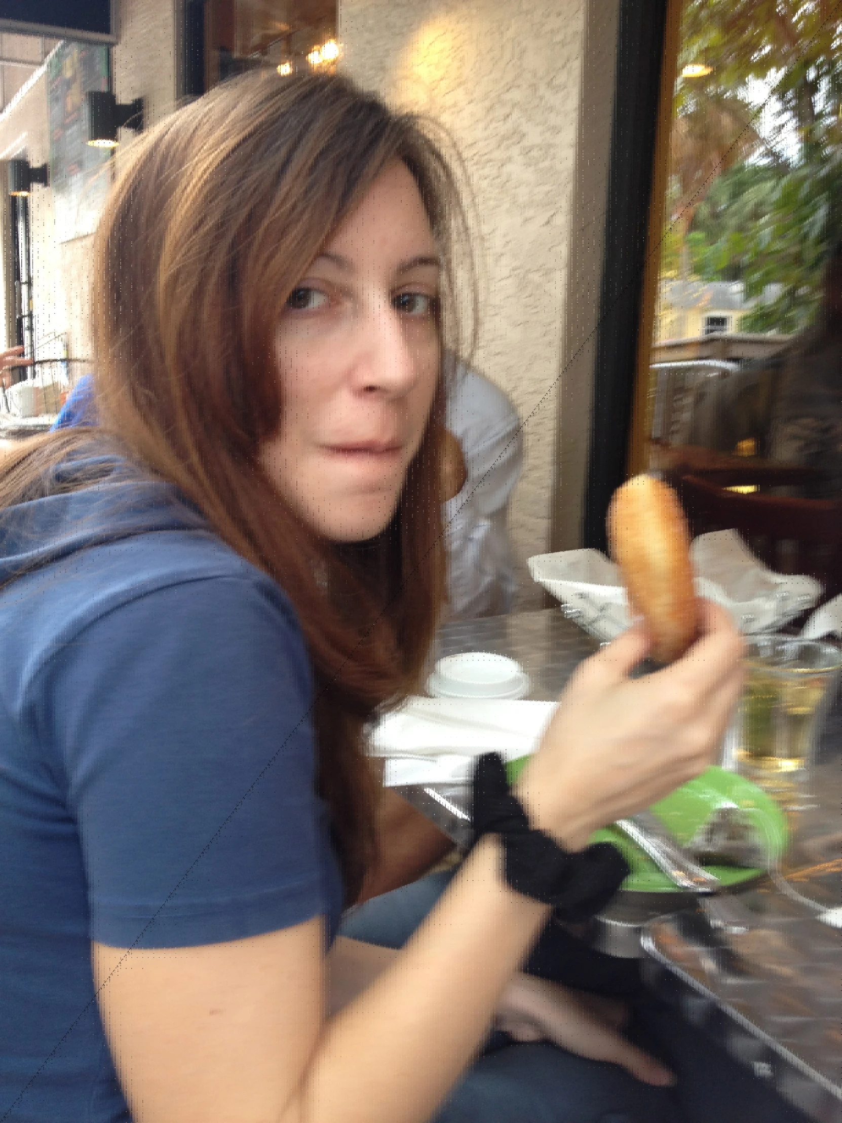 a woman eating a donut while sitting in front of her