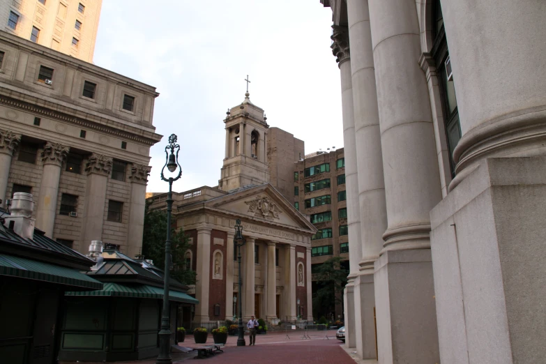 a small street scene, with columns and an old building in the distance