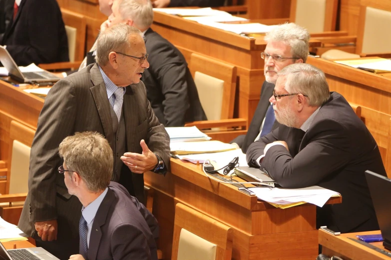 some men are in suits and siting at desks