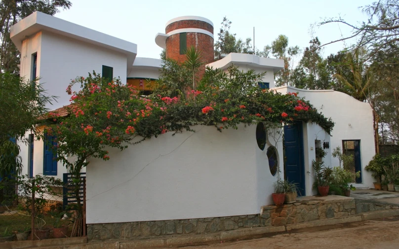 red flowers are growing over the wall of this house