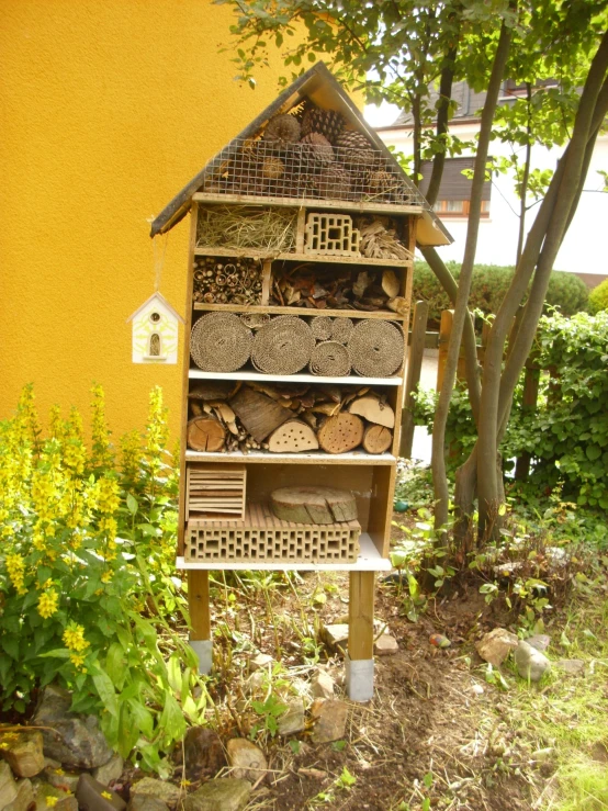 a yellow building with a bee house in the yard