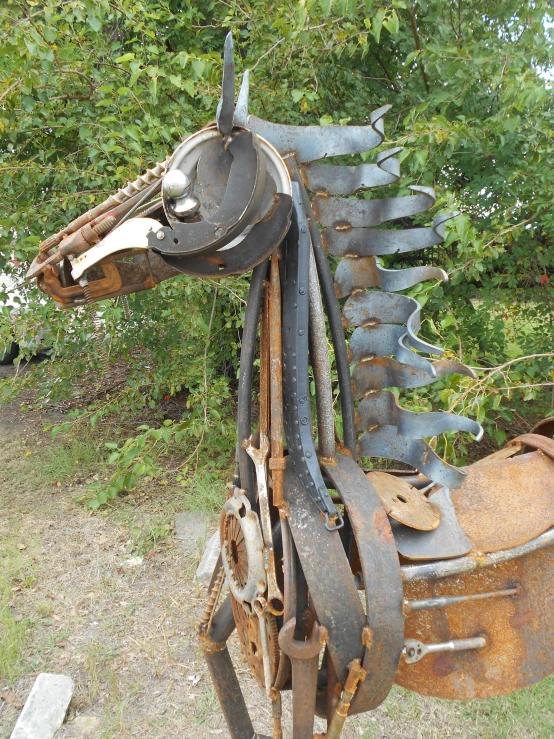 metal horse standing in a field with trees