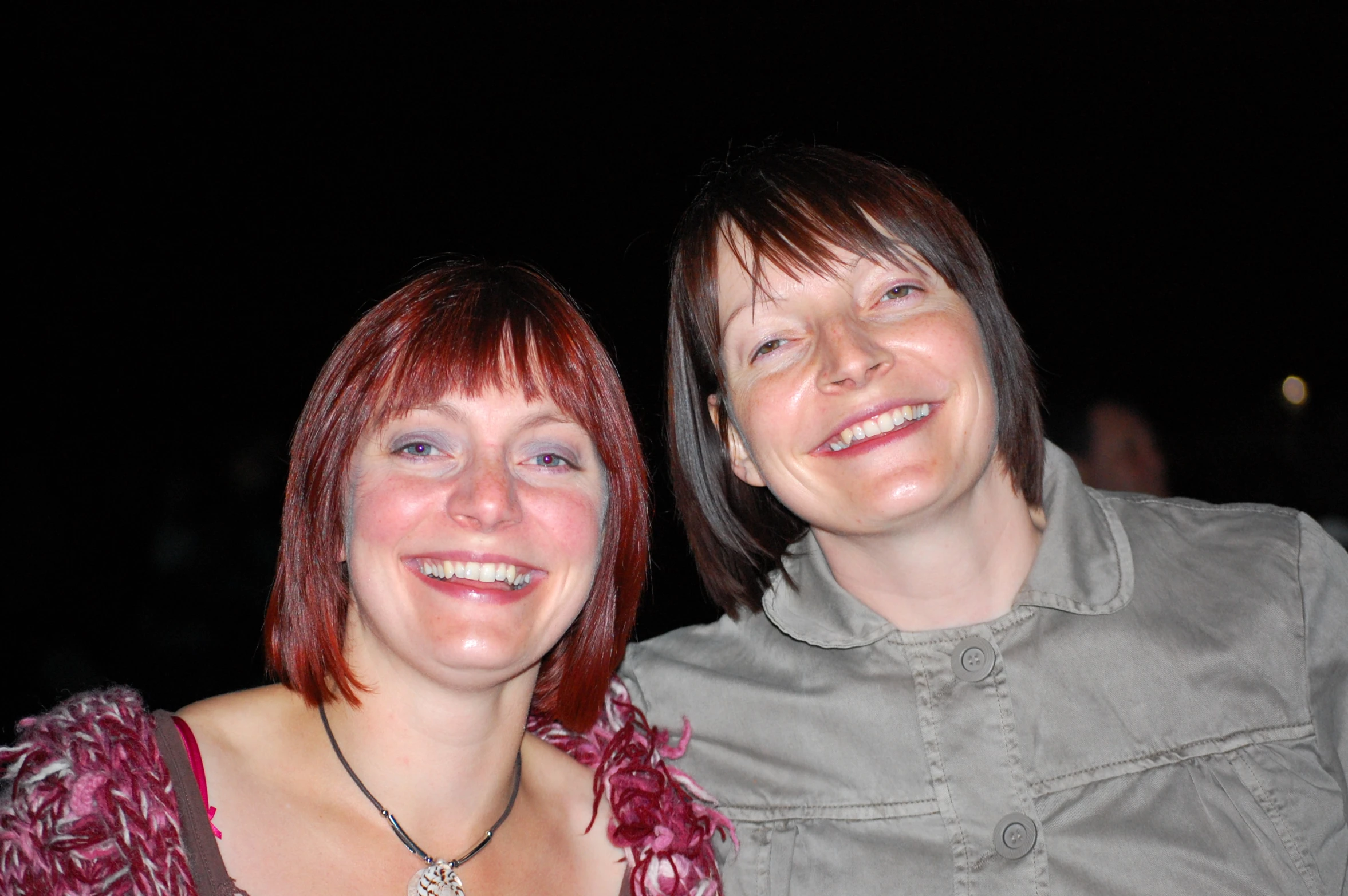 two women wearing shirts, one is looking at the camera