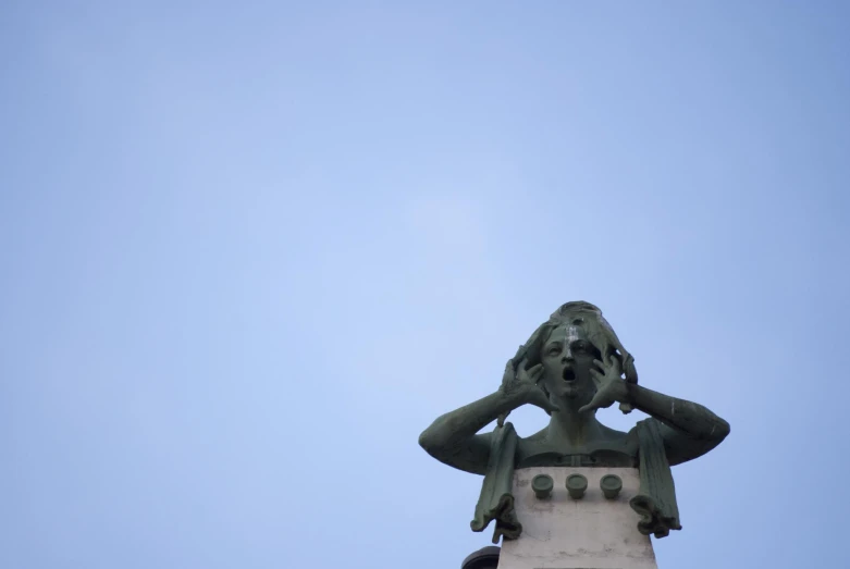 the view from the base of a statue of a man looking up at it with his head in the air