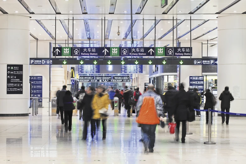 a crowd of people walking inside of an airport