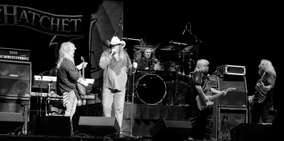 a man and two woman standing on stage with guitars