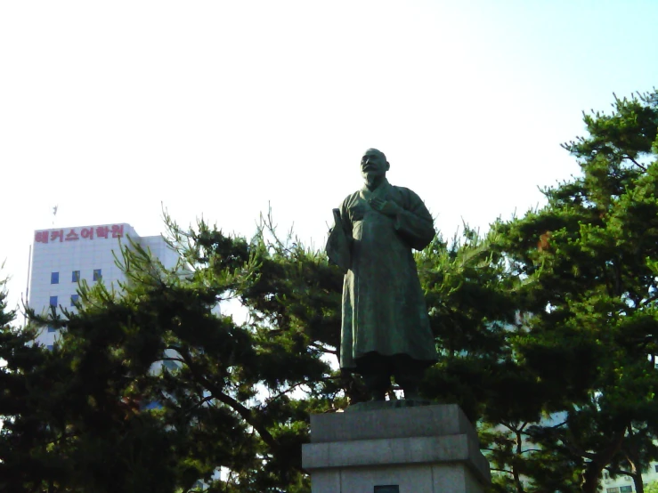 a statue of a person standing in front of trees