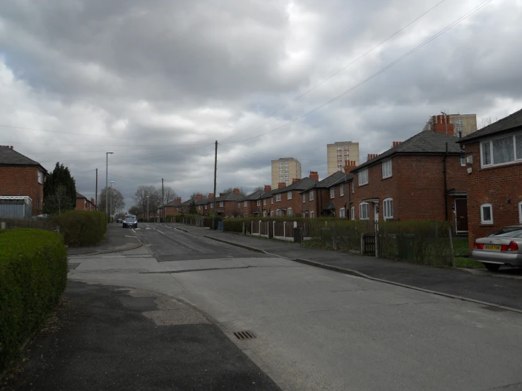 an empty street next to a line of brick buildings