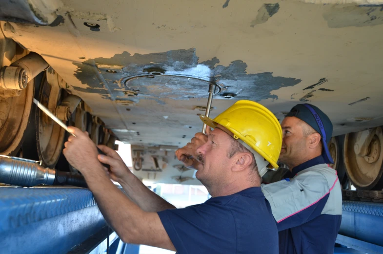 two men working on pipes inside a building