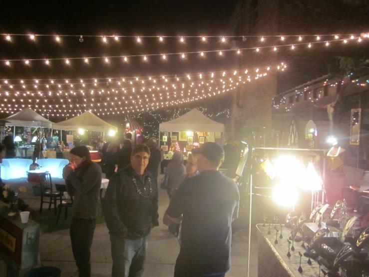 people walk through the crowded open market at night