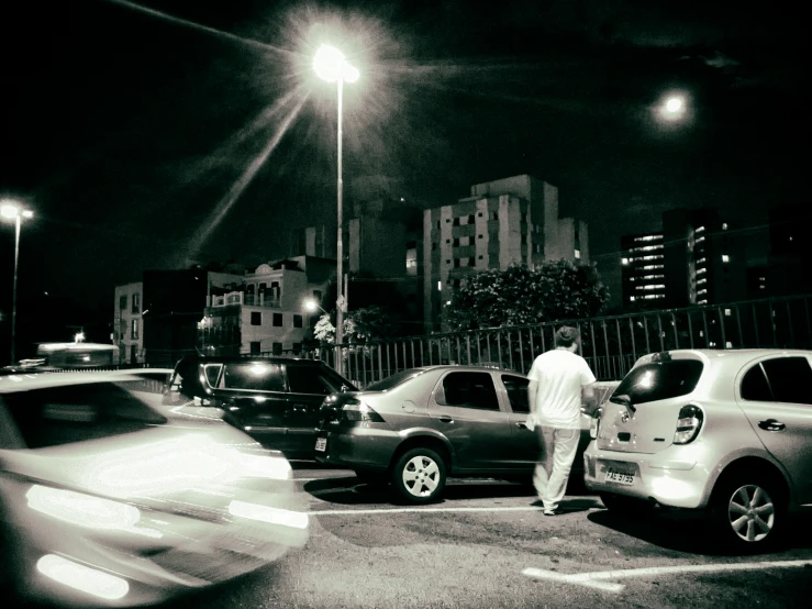 black and white pograph of cars driving through a street