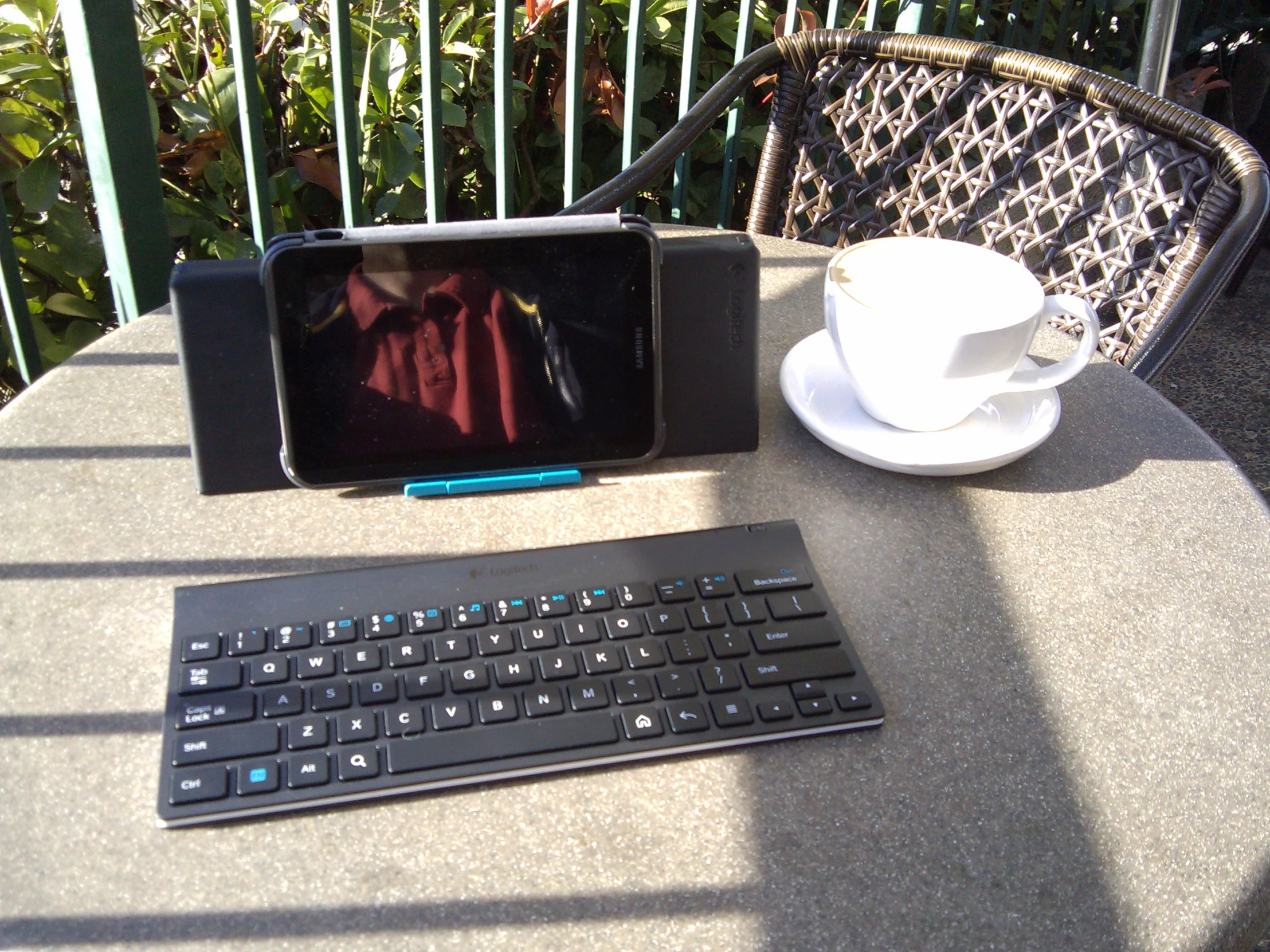 a tablet pc sitting on top of a table with a keyboard