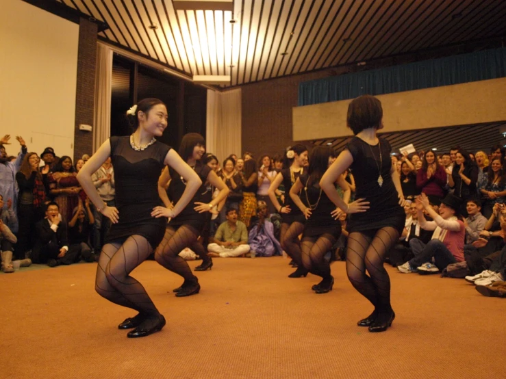 there are several women dancing around in the audience