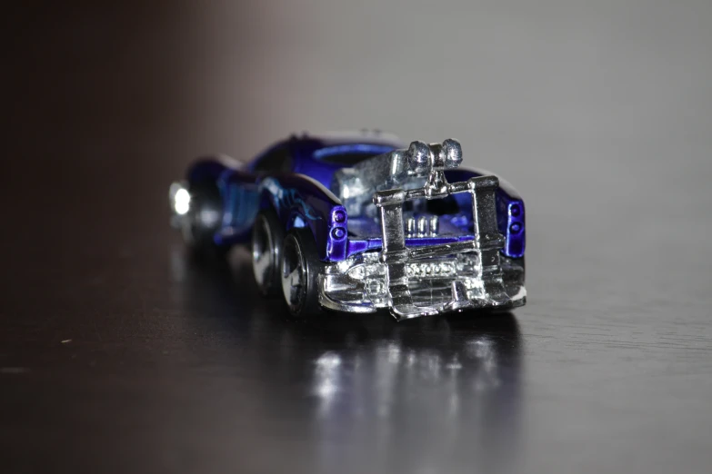 a toy car made of glass sits on a surface