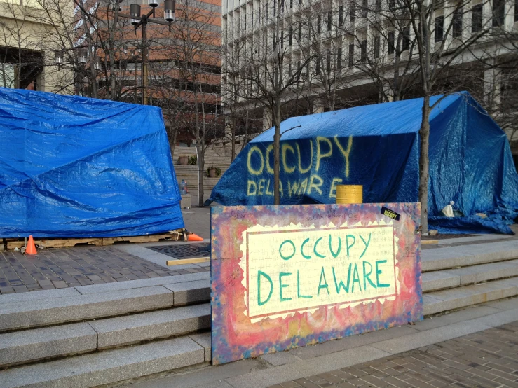 signs on the side of some steps with a lot of blue tarps