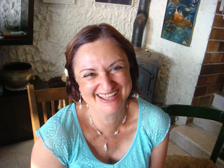 woman smiling at camera near fireplace indoors