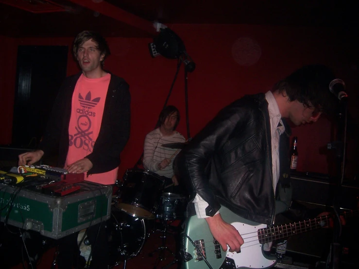 two men standing and playing music together at a party