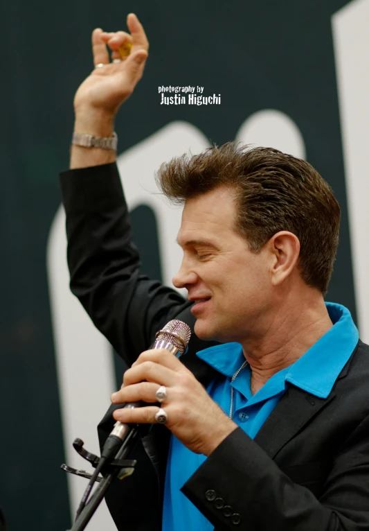 a man speaking into a microphone and gesturing
