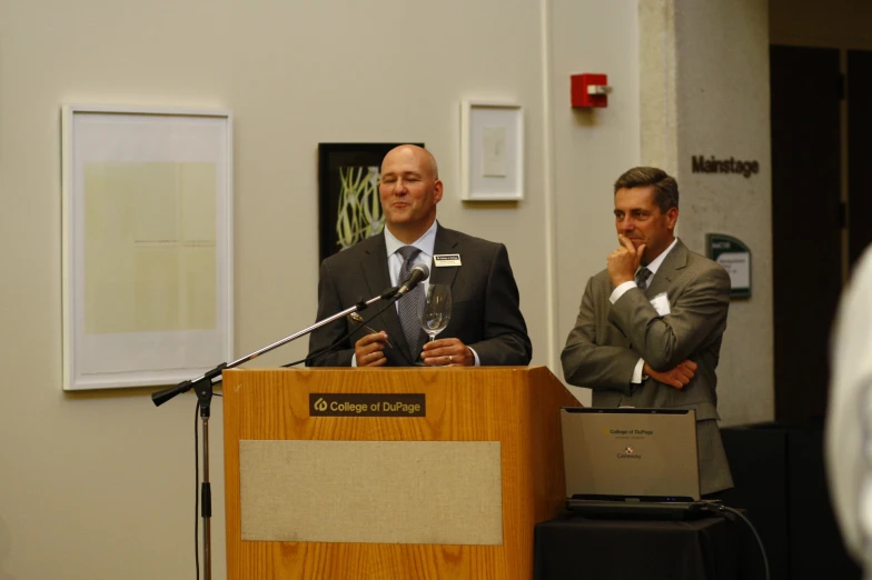 two men standing next to each other at a podium