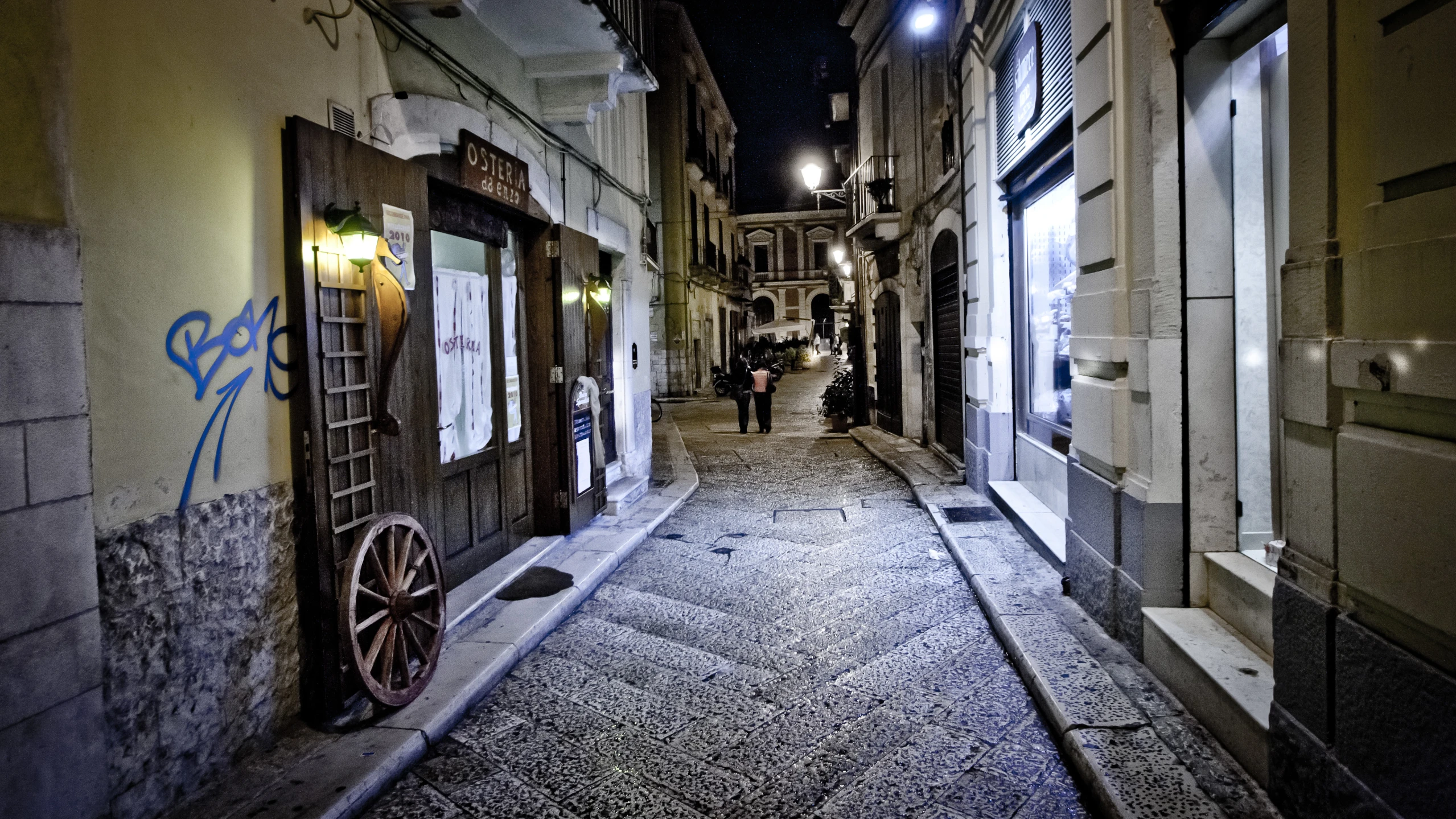 a narrow alley with people walking in and out of it