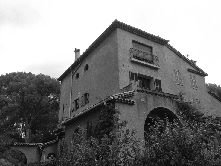 an old building surrounded by plants and trees