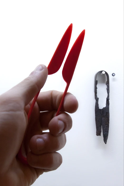 a pair of scissors being held to a tiny piece of paper