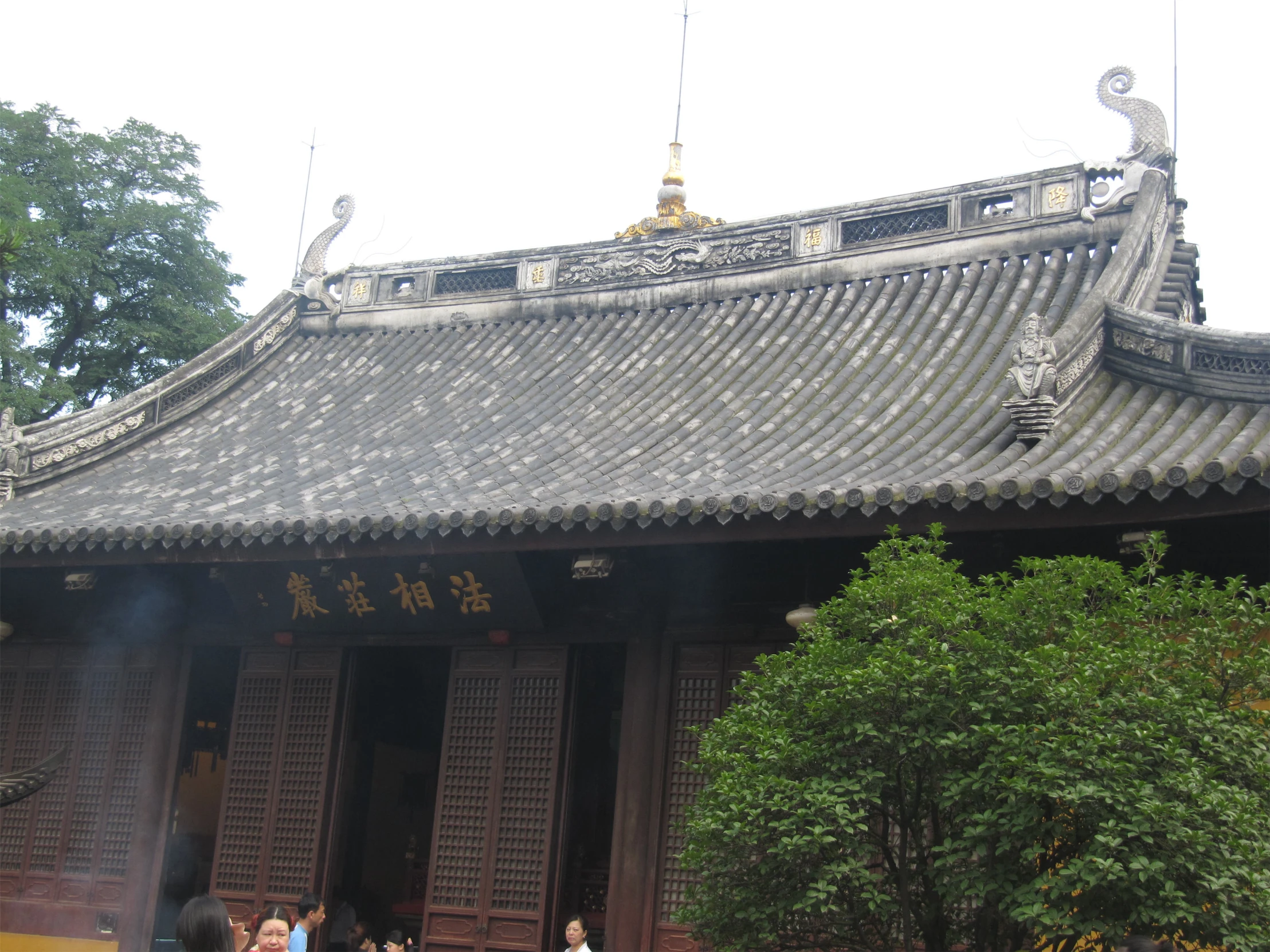 a group of people standing around near an asian style building