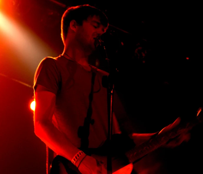 a man is playing the guitar while in the dark