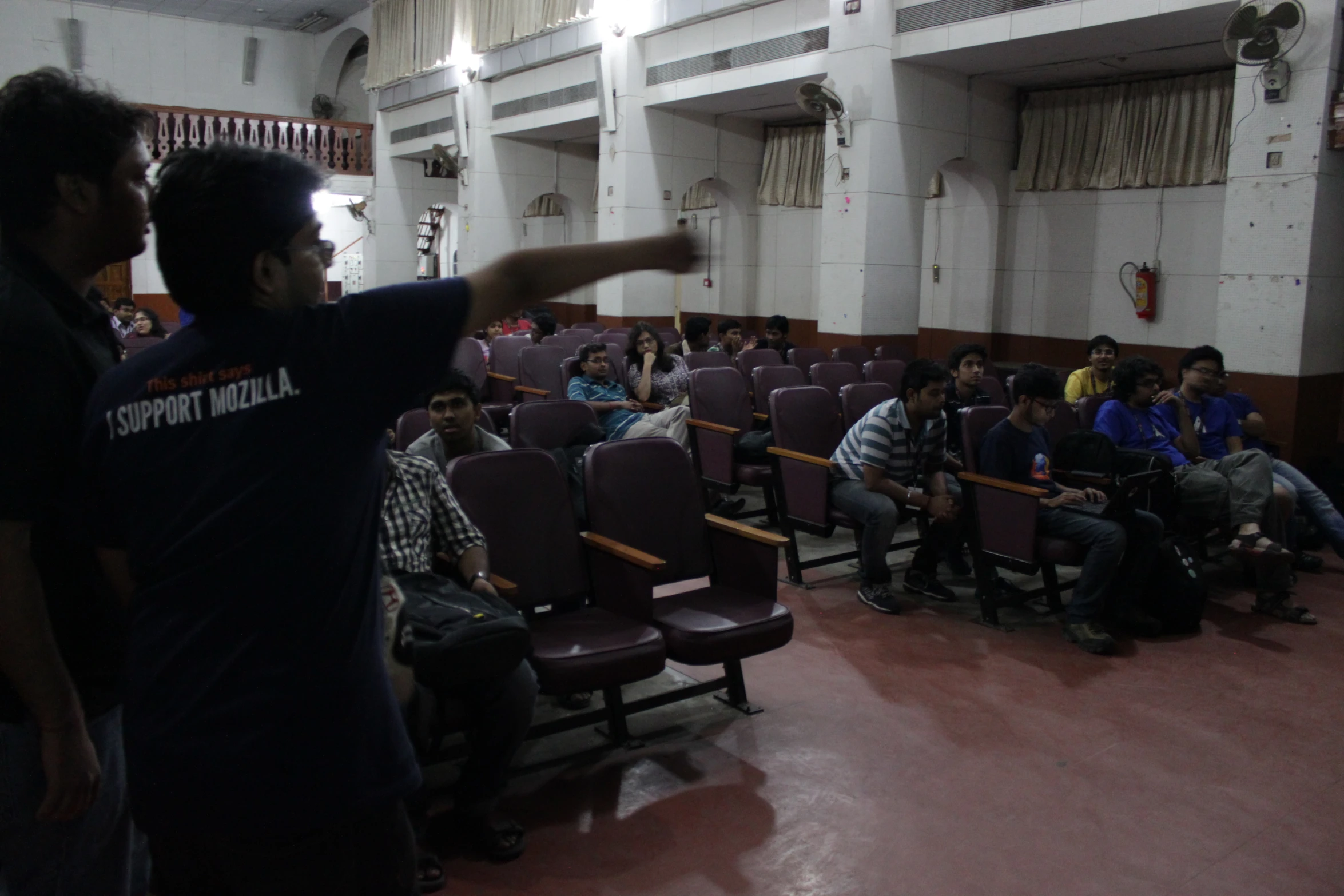 a man directing an audience in front of an auditorium