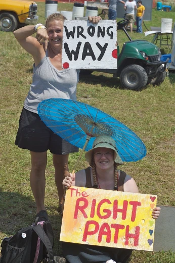 two women holding up signs outside at a protest