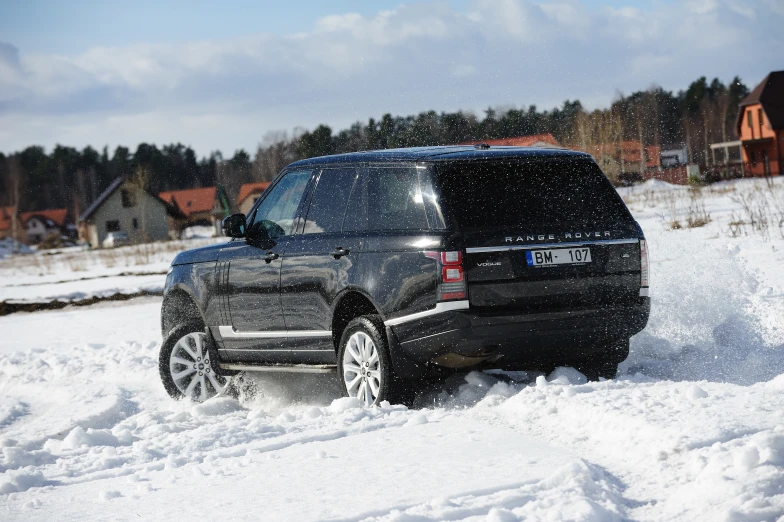 black vehicle driving on snowy roadway in residential area