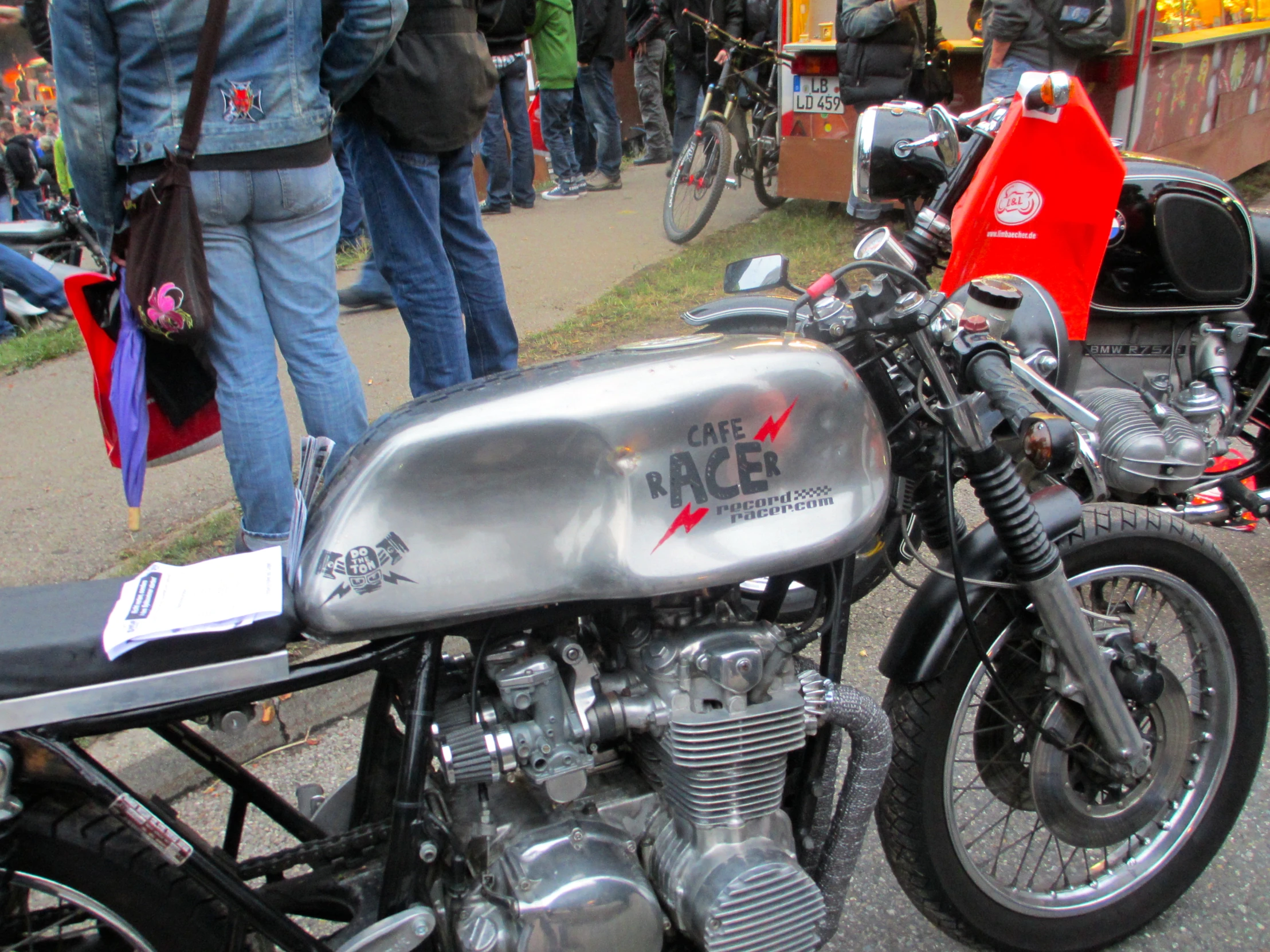 a silver and black motorcycle parked in front of a crowd