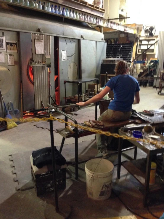 a man in blue shirt working on a piece of equipment