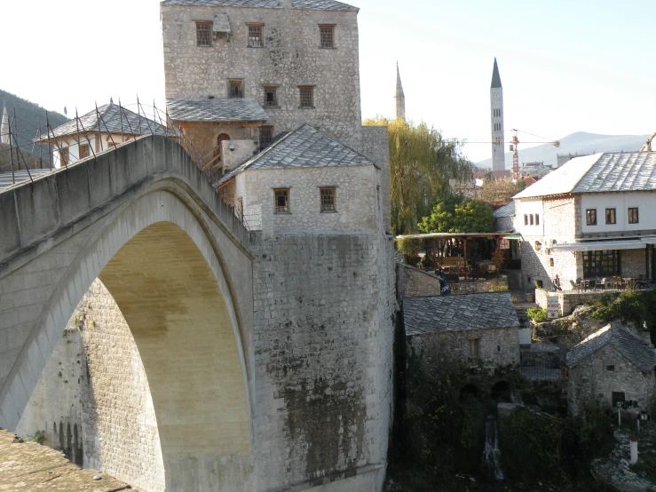 the old stone bridge is built next to the city