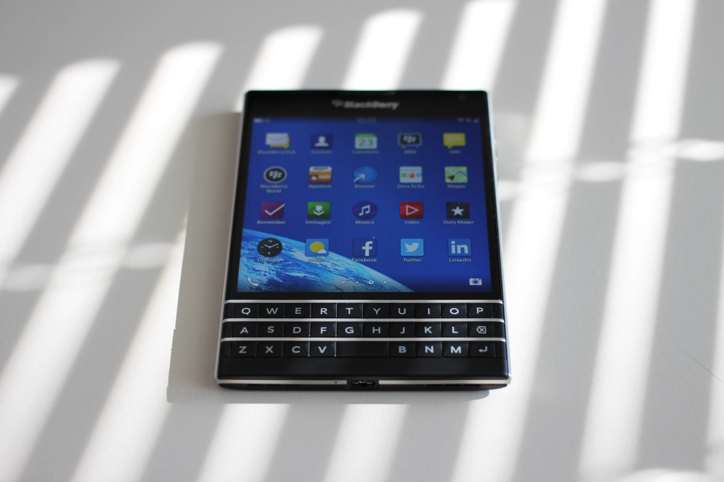 a blackberry smartphone sitting on a table next to the sunlight