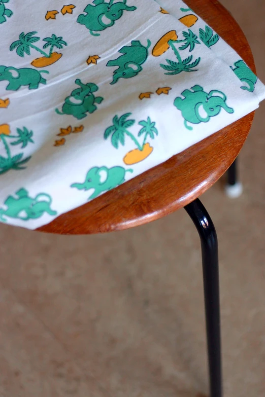 a wooden chair with white and green print on the back