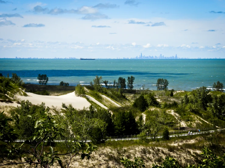 a view of the water and sand dunes in the distance