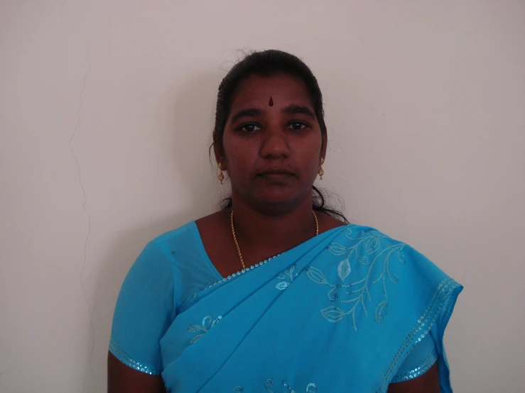 a woman wearing a blue sari and a necklace