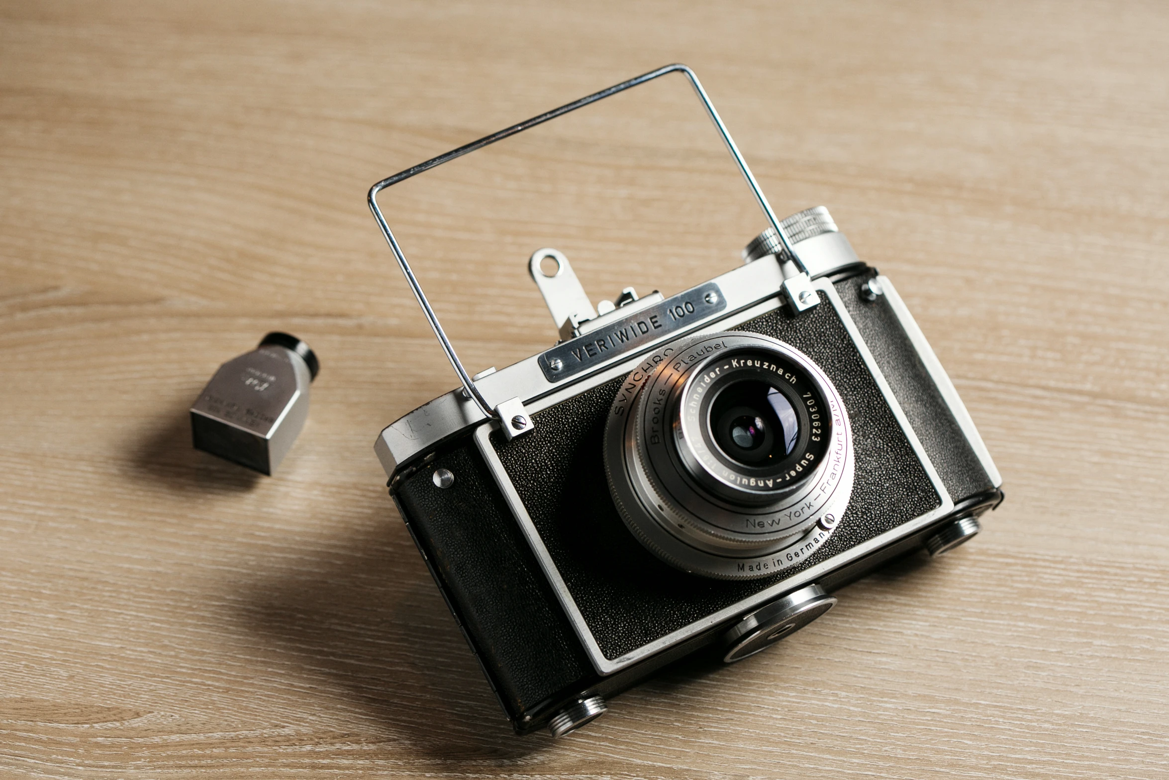 an old fashioned camera with an old adapter sitting beside it