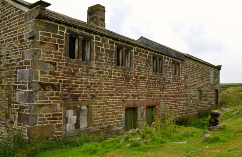 an old brick building on the side of a hill