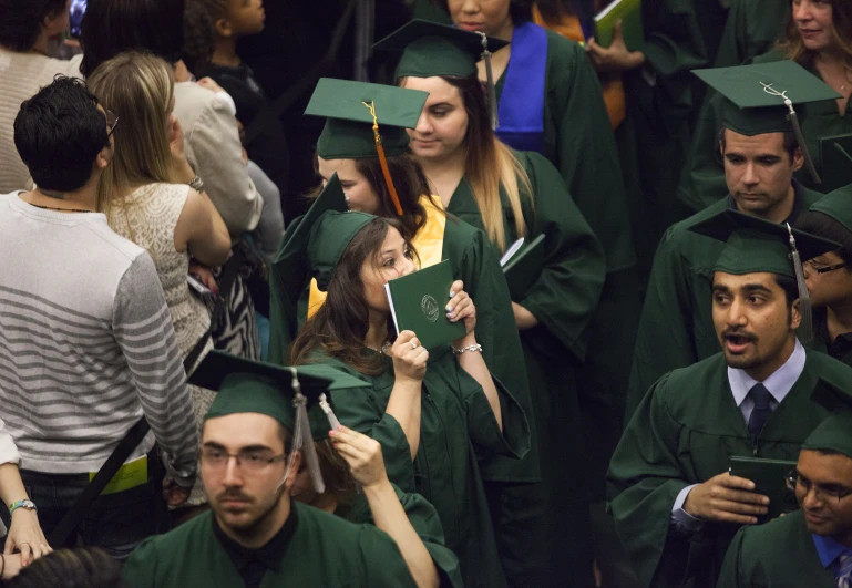 a group of graduates pose in front of other graduates