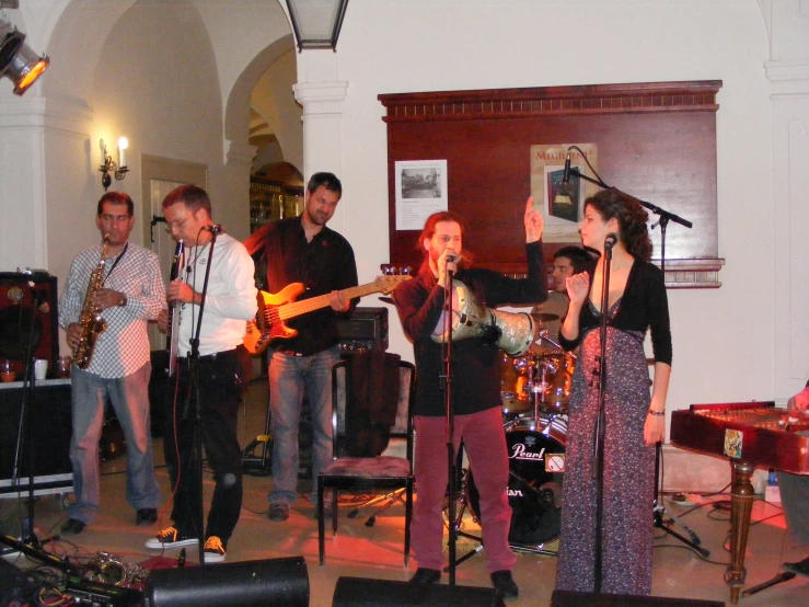 a band performing in an indoor room in front of a piano