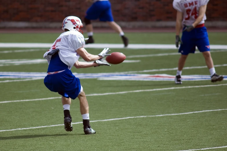 a young man holding an american football in front of another