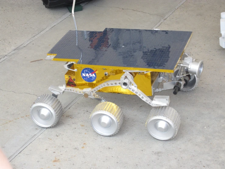 a yellow and black device is sitting on concrete