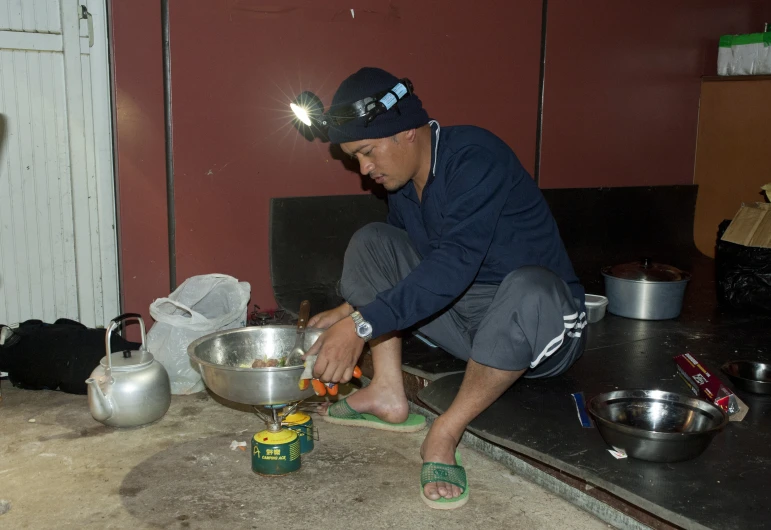 a man putting ingredients in a bowl on the stove