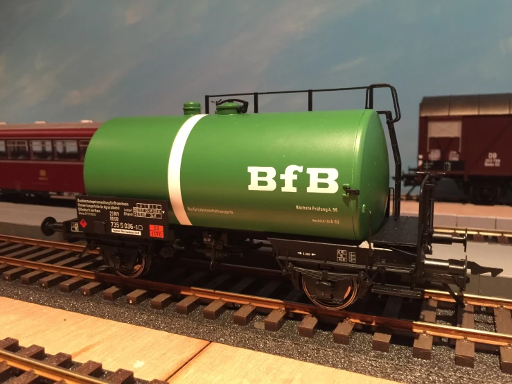 a green tanker car sitting on a track