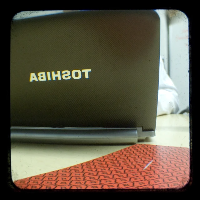 there is a laptop computer that has a red rubber mat